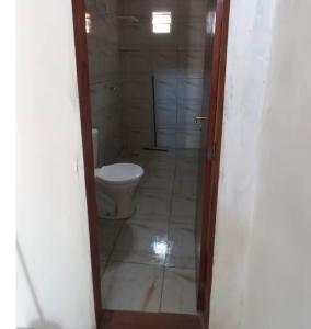 a bathroom with a toilet and a door to a room at Casa Brisa do Mar in Tamandaré +16 photos