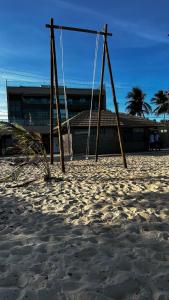 a swing set in the sand on the beach at Casa Brisa do Mar in Tamandaré +15 photos