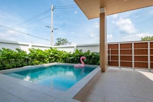 a swimming pool with a pink flamingo in a backyard at Minimalistic Pool Villa in Ao Nang 