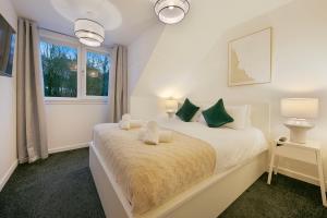 ein Schlafzimmer mit einem Bett mit grünen Kissen und einem Fenster in der Unterkunft Rooemah Lodge - Grampian Lettings in Caskieben