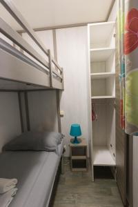 a small bedroom with a bunk bed and a blue lamp at Le Cottage 61 - Au Bonheur de Sophie in Le Vauclin