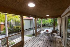 a screened porch with a table and chairs on it at Le Cottage 61 - Au Bonheur de Sophie in Le Vauclin +8 photos