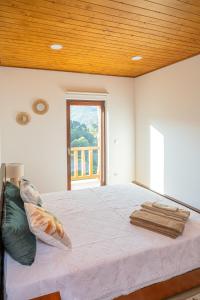 ein Schlafzimmer mit einem großen Bett und einer Holzdecke in der Unterkunft Casas de São Pedro in Rio Caldo