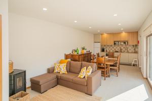 ein Wohnzimmer mit Sofa und eine Küche in der Unterkunft Casas de São Pedro in Rio Caldo + 12 Fotos