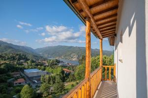 einen Balkon mit Blick auf den Fluss und die Berge in der Unterkunft Casas de São Pedro in Rio Caldo