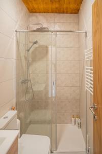 eine Dusche mit Glastür im Badezimmer in der Unterkunft Casas de São Pedro in Rio Caldo