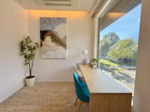 una oficina con escritorio y una gran ventana en Vive Boutique Hotel - Echoland, en Hakuba