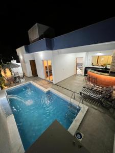 a swimming pool with a ping pong table in a building at Piscina Aquecida Quartos com Ar cond 700m Praia in Peruíbe