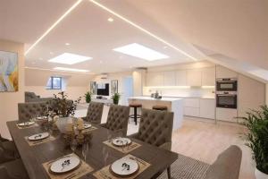 een keuken en woonkamer met een tafel en stoelen bij Westland Lodge in Brookmans Park