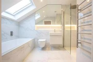 een badkamer met een bad, een toilet en een wastafel bij Westland Lodge in Brookmans Park +20 foto's