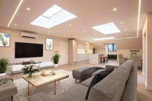 een woonkamer met een bank en een tv bij Westland Lodge in Brookmans Park