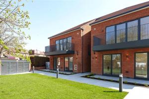 een bakstenen gebouw met een gazon ervoor bij Westland Lodge in Brookmans Park