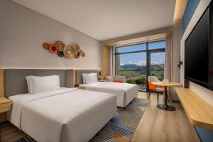 a hotel room with two beds and a flat screen tv at Holiday Inn Express Nalati By IHG in Narat