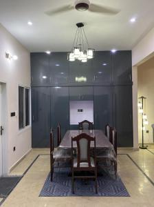 卡拉奇Modern Executive Suite的餐厅里摆放着桌椅，墙壁是黑色的。