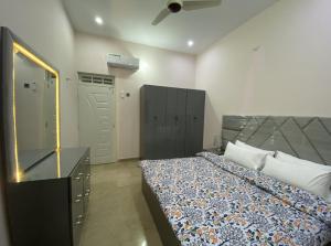 卡拉奇Modern Executive Suite的一间卧室配有一张带梳妆台和镜子的床