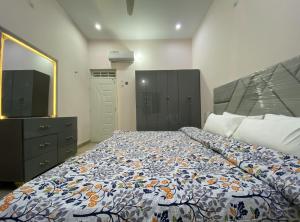 卡拉奇Modern Executive Suite的一间带床、梳妆台和电视的卧室