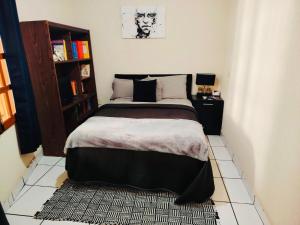 a bedroom with a bed and a book shelf at Casa Luna in Morelia