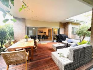 a living room with a wooden table and chairs at Oasis by the Bay - 4 bedroom Beach House in Corlette