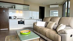 a living room with a couch and a table at A Window on the Bay in Metung +10 photos