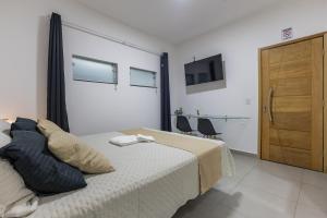 Suíte - Ideal para conexões no aeroporto de Guarulhos في جوارولوس: غرفة نوم بسرير وكابينة وتلفزيون