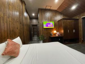 a bedroom with a bed and a tv on a wall at Căn hộ Đà Lạt Cảnh in Da Lat