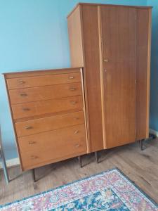 een houten kast naast een tapijt bij Sweetdreams in Hornchurch