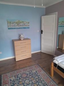 een slaapkamer met een bed, een dressoir en een deur bij Sweetdreams in Hornchurch