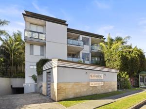 an apartment building with a sign in front of it at Bright 2-Bed Apartment Near Narrabeen Beach in Narrabeen