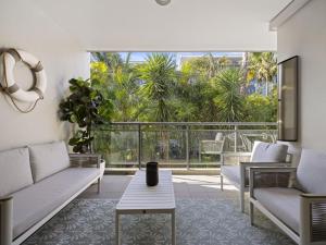 a living room with a couch and a table at Bright 2-Bed Apartment Near Narrabeen Beach in Narrabeen +1 photo