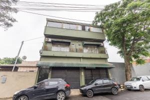 Suíte - Ideal para conexões no aeroporto de Guarulhos في جوارولوس: سيارتين متوقفتين امام مبنى