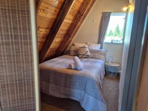 a bedroom with two beds with a stuffed animal on the bed at Aurora A-Frame Twizel in Twizel