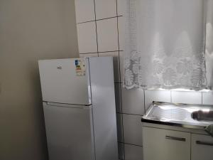 una nevera blanca en una cocina con ventana en UNIJUI, en Ijuí 6 fotos más