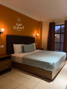 克雷塔罗Hotel San Rafael的一间卧室，墙上有一张床和一块牌子 更多18张照片