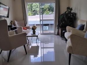 Una sala de estar con sillas y una mesa y una ventana. en UNIJUI, en Ijuí