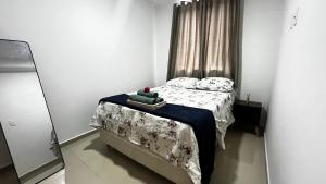 a small bedroom with a bed and a mirror at Refúgio com quintal gramado in Parnamirim +29 photos