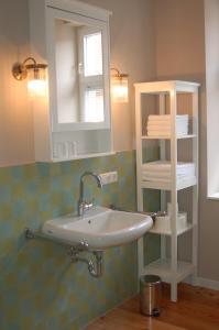 a bathroom with a sink and a mirror at Schloss-und Seeblick Apartment in Rheinsberg +35 photos