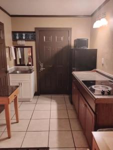een keuken met een zwarte deur en een tegelvloer bij Gated 2 Double Bed Studio with Full Kitchen 112 in Baton Rouge +15 foto's