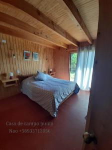 een slaapkamer met een bed in een houten huis bij casa de campo punta nao in Rolecha