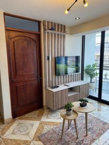 库斯科Qosqo Air Loft的一间带门和电视的客厅 更多14张照片