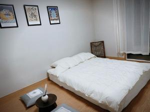 a bedroom with a bed and a table with a laptop at Daejeon Dunsan Starworks in Daejeon