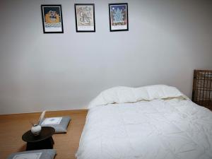 a bedroom with a white bed with pictures on the wall at Daejeon Dunsan Starworks in Daejeon