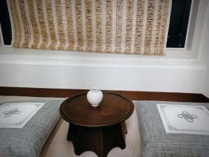 a table with a vase on it next to two beds at Daejeon Dunsan Starworks in Daejeon