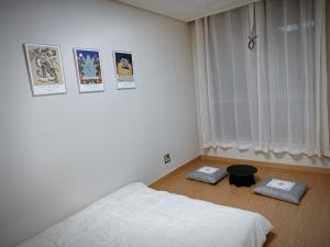 a white bedroom with a bed and a window at Daejeon Dunsan Starworks in Daejeon +9 photos