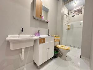 a white bathroom with a sink and a toilet at Casa com 02 Quartos em Balneário Camboriú in Balneário Camboriú +11 photos