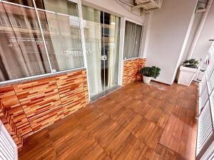 an empty room with a wooden floor and a balcony at Casa com 02 Quartos em Balneário Camboriú in Balneário Camboriú