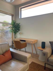a living room with a desk and a couch at Nelson Bridge House in Nelson +8 photos