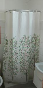 una tenda da doccia con alberi dipinti sopra in un bagno di Departamento 1ambiente a metros de la playa Zona Centro a Mar del Plata 1 altra foto