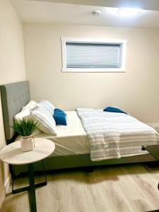 een slaapkamer met een bed met een tafel en een raam bij Cozy guest house in Regina