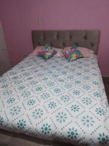 un letto con trapunta e cuscini sopra di Hermoso departamento de tres dormitorios a Cuenca