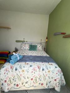 a bedroom with a bed with a comforter on it at Sobradinho da Lagoa in Niterói